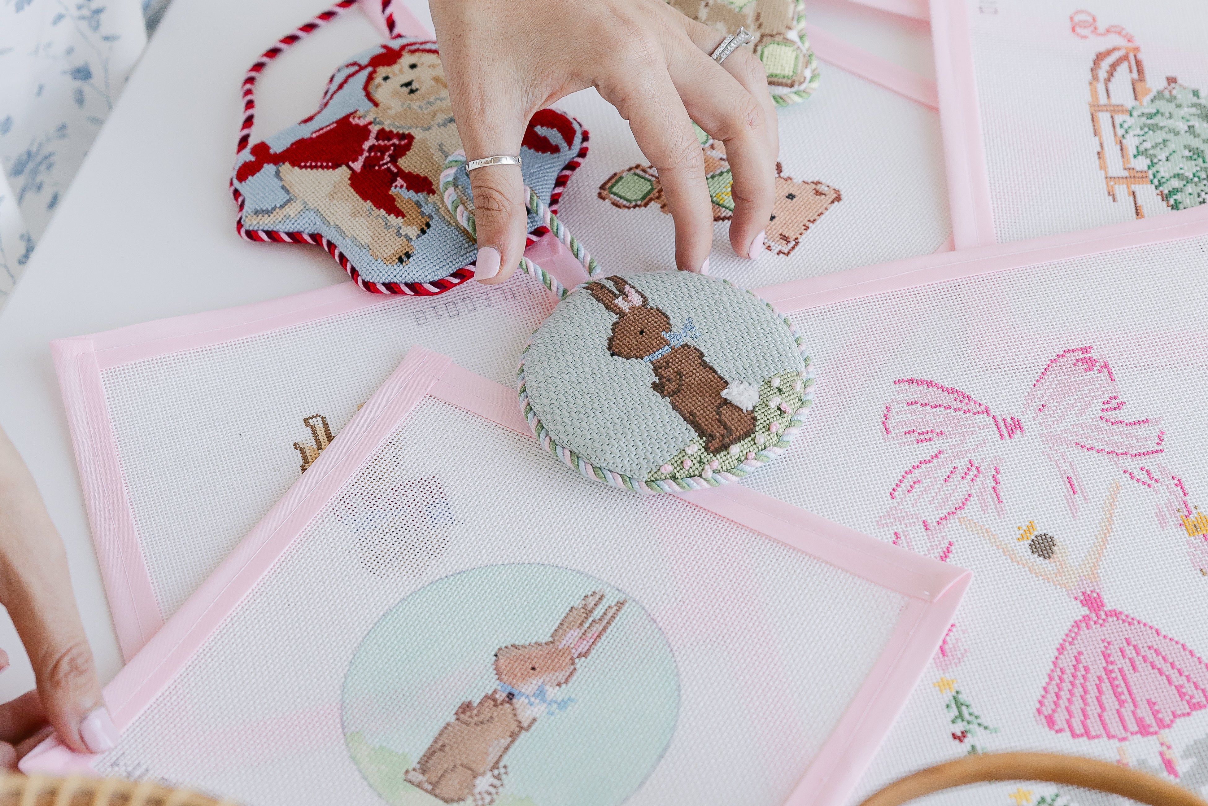 Needlepoint pieces with teddy bears on a table