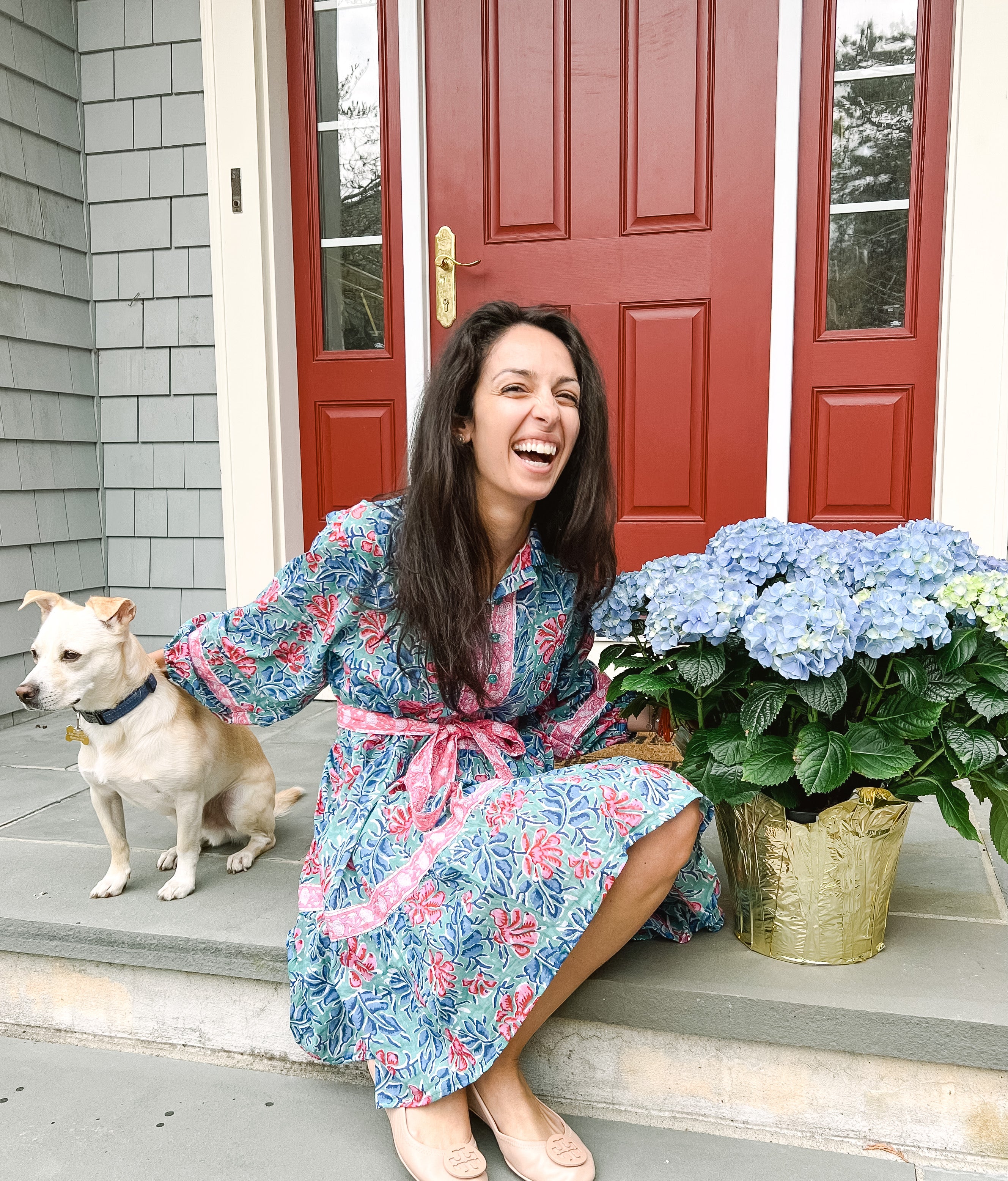 image of girl in floral dress with yellow dog and pot of hydrangeas