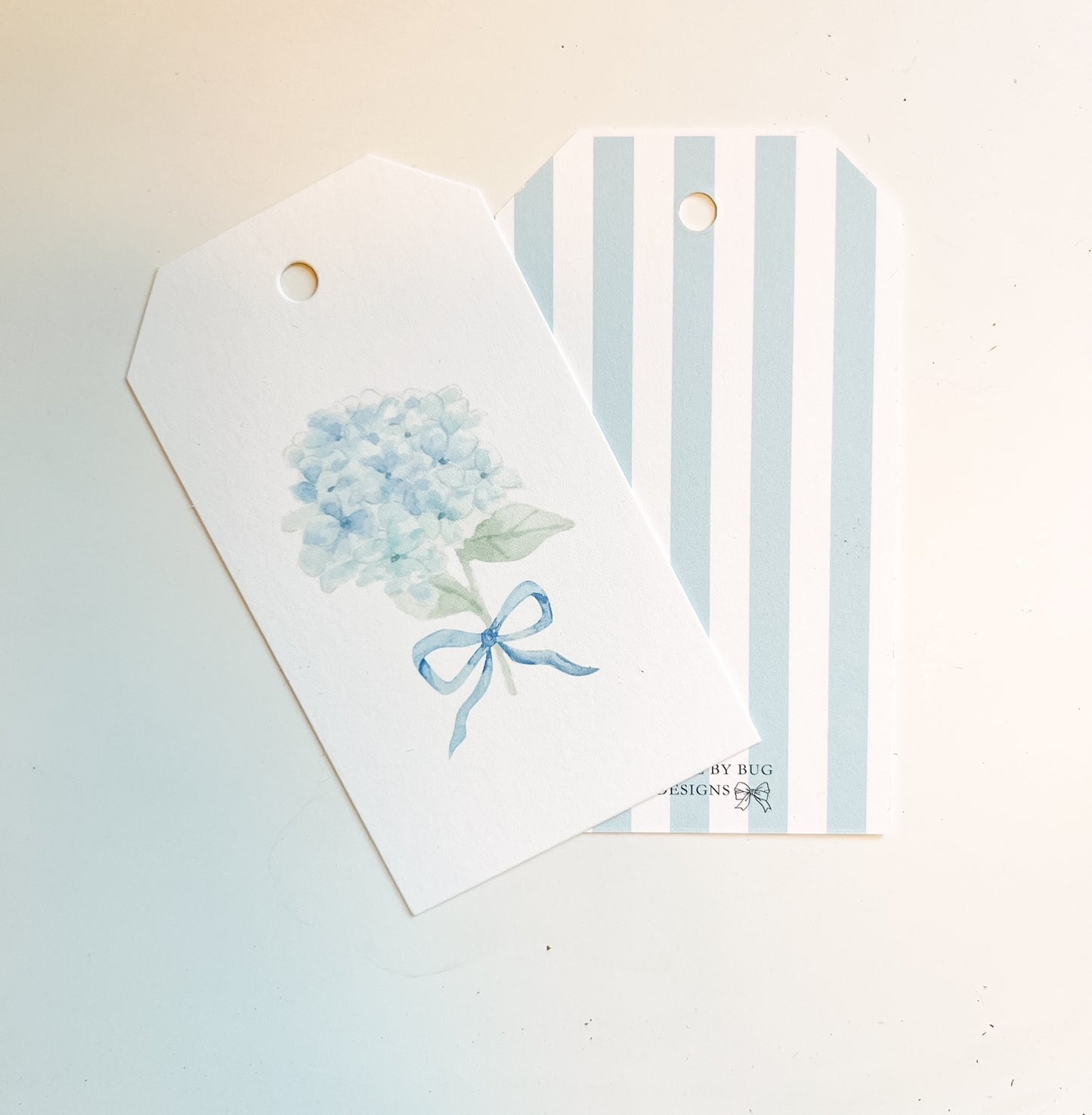 Blue watercolor hydrangea with blue bow with striped backgroundon gift tag 