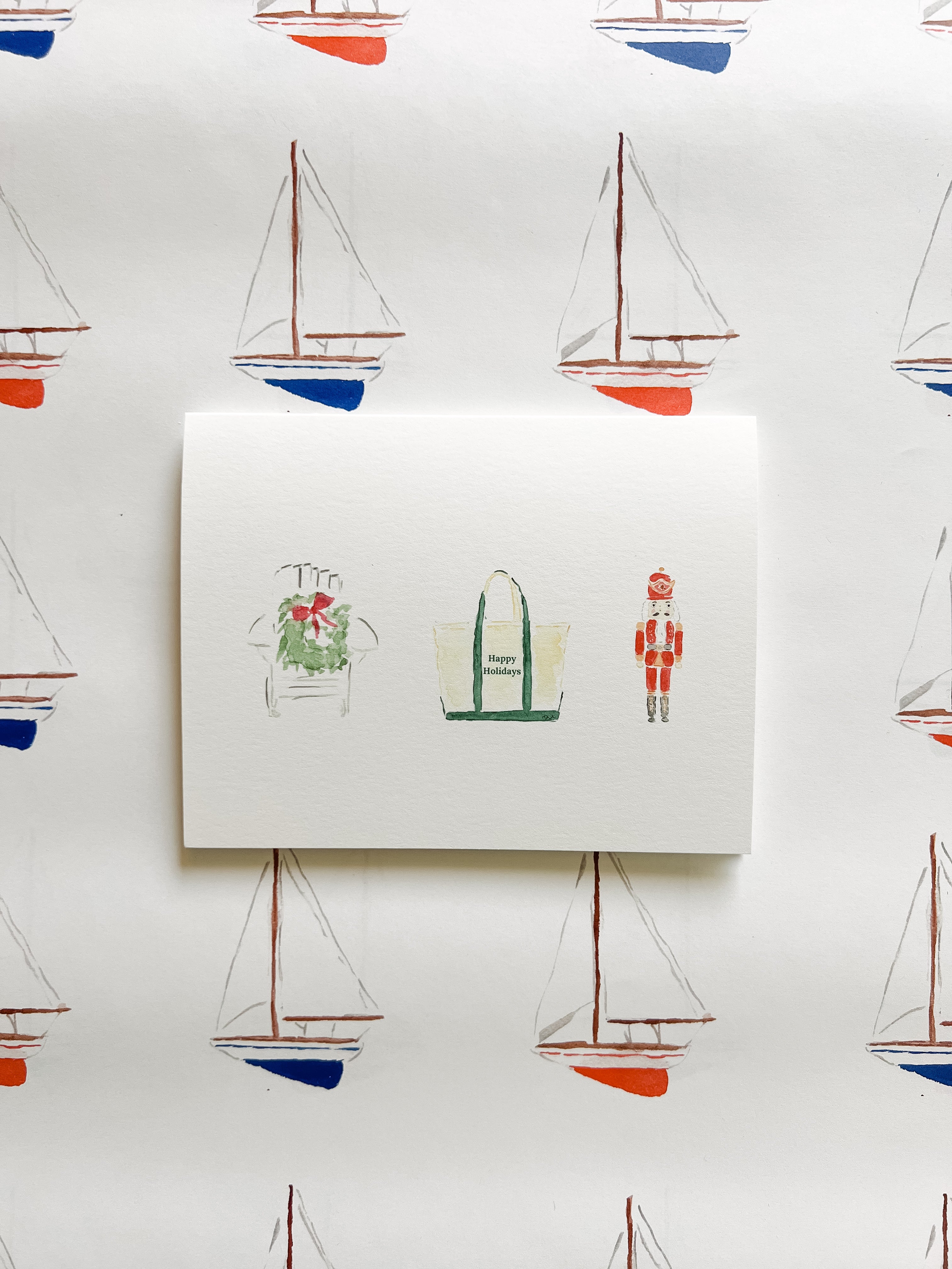 Note card with illustrations of a bag, a plant, and a soldier on a background with sailboat patterns.